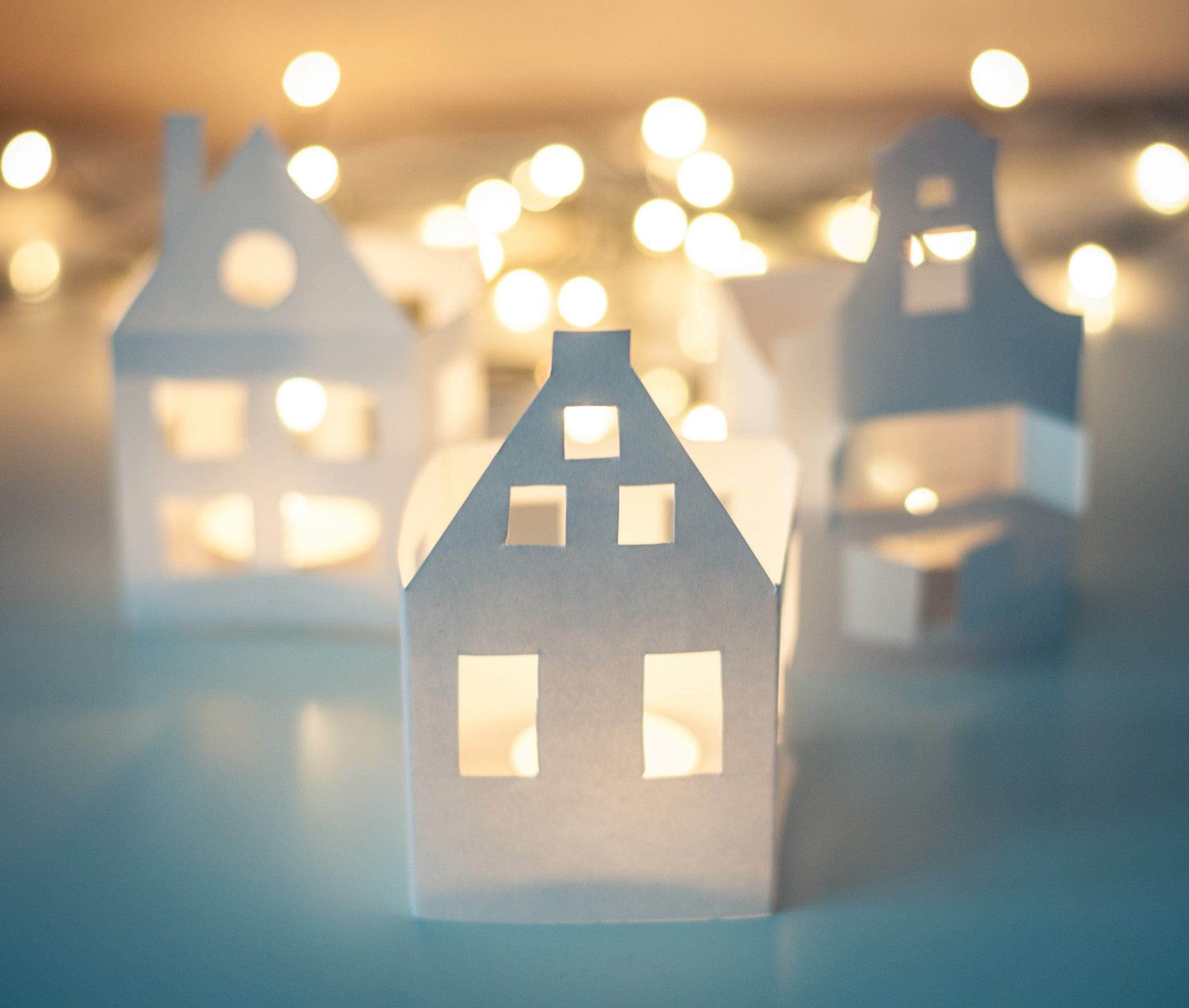Illustration: utklippta pappershus med ljusslinga.